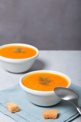 Pumpkin and carrot soup with fresh dill on table