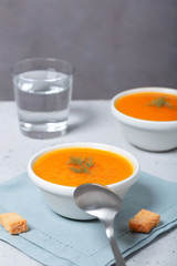 Pumpkin and carrot soup with fresh dill on table