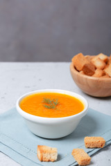 Pumpkin and carrot soup with fresh dill on table