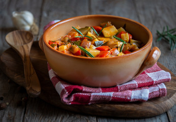 Chopped cooked vegetables on dark wood. Traditional ratatouille with zucchini, bell pepper and eggplant