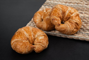 Freshly tasty baked croissants on dark stone background