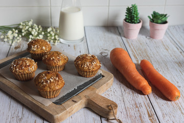 Fresh homemade delicious carrot muffins decorated with oat flakes and brown sugar on rustic table