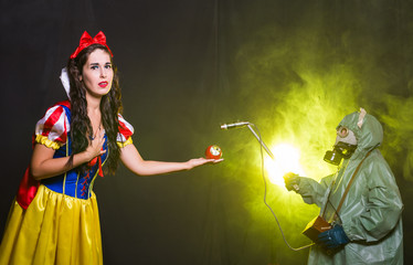 Woman wearing a fairy tale dress holding an apple with radiation symbol. Environmental problems...