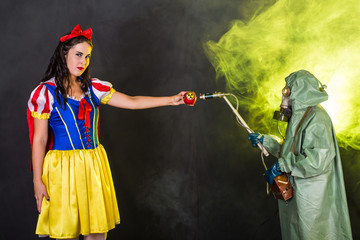 Woman wearing a fairy tale dress holding an apple with radiation symbol. Environmental problems...