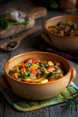 Chopped cooked vegetables on dark wood. Traditional ratatouille with zucchini, bell pepper and eggplant