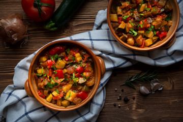 Chopped cooked vegetables on dark wood. Traditional ratatouille with zucchini, bell pepper and...