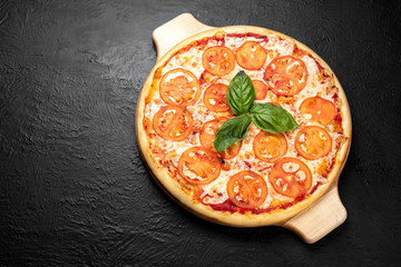 Pizza MARGARITA on a black background, tomato-based with mozzarella, Basil, parsley and tomatoes