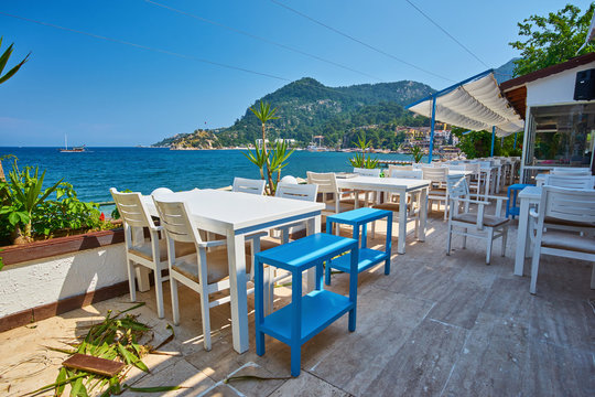Fototapeta Traditional greek street cafe with flowers.