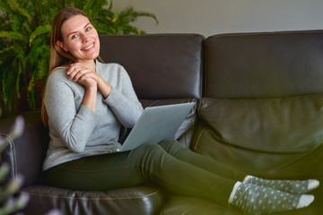 Obraz premium Happy beautiful woman using a laptop computer at sofa in home