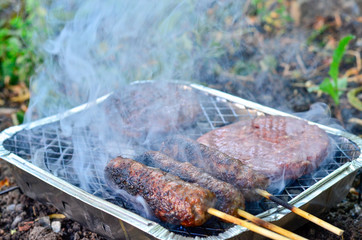 a disposable barbecue with meat grilling