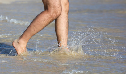 A man in swimming trunks on the seashore.