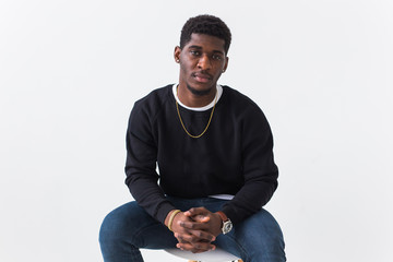 Portrait handsome young black man dressed in jeans and sweatshirt on white background. Street fashion and modern youth culture.
