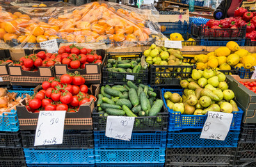 Fresh fruits and vegetables on display in a market in Bucharest, Romania. Translation on paper:...