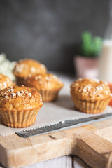 Fresh homemade delicious carrot muffins decorated with oat flakes and brown sugar on rustic table