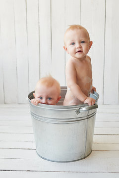 Kids hygiene. Shampoo, hair treatment and soap for children. Kid bathing in large tub. Twin boys wash, infant hygiene, health and skin care. Baby in bath. Children's Day.