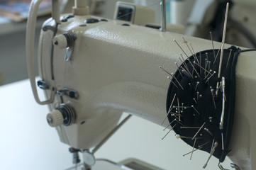 Needle and foot of sewing machine closeup as manufactoring background