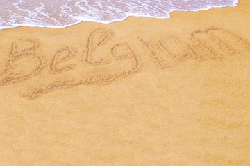 Grey, wet, sea wave washed up on the beach in the summer morning. Inscription beach country Belgium on the coast of Europe. Space for text and drawing. blurry; celebration