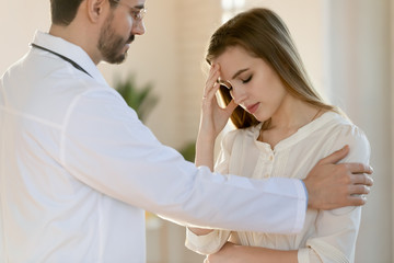 Supportive young male doctor in white medical uniform show empathy and care to upset female patient, man GP or physician support distressed woman client, comfort help with bad checkup results
