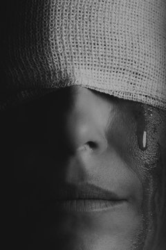 Conceptual photo of a hurt woman crying with bandage around her head artistic concersion