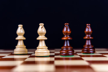 four chess bishops on a chessboard on a black background