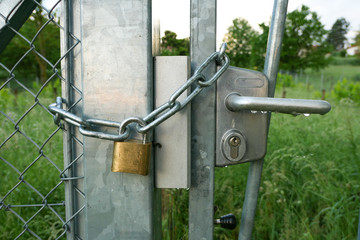 Metal chain with a padlock, which closes the gate of a garden gate. Anti-intrusion security system.