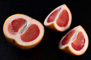 Fototapeta na wymiar red grapefruit on black background