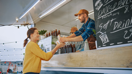 Food Truck Employee Hands Out a Freshly Made Gourmet Burger to a Happy Young Female. Street Food...