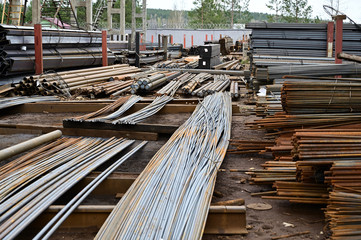 Outdoor photos of black metal lie in stacks of pallets