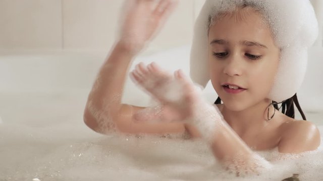 The girl makes a beautiful hairstyle of white and air foam, 4K UHD still video camera, 2x slow motion.