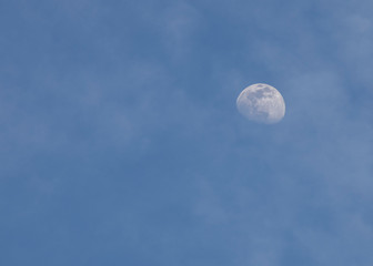 Fototapeta na wymiar almost full moon in the blue sky