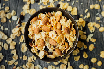 Cornflakes in a brown clay plate on a shabby wooden background