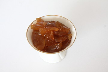 Apple jam in a white porcelain vase on a white background