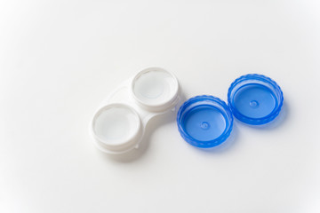 Contact lenses are in solution in the contact lens container on a light background. Contact lenses for correcting vision.