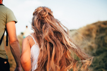 girl in a white dress with her hair runs up the mountain