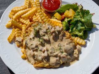 A traditional dish in Latvia. Carbonate in mushroom sauce.