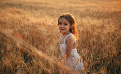 girl in a white dress stands in a field