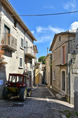 Fototapeta na wymiar A narrow street between the old houses of the village of Pietraroja, in the province of Benevento, Italy