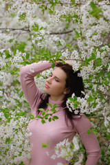 portrait of a young girl in a blossoming apple tree