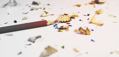Single Soft Red Wooden Pencil and Randomly Sorted Pencil's Shavings on White Background .Wooden...