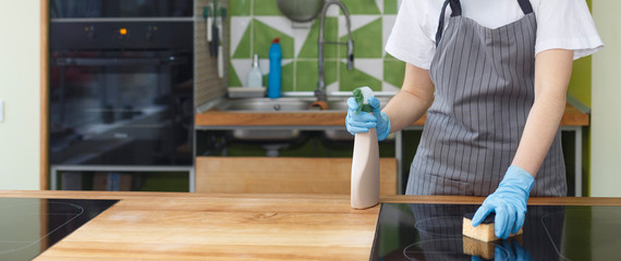 Unrecognizable woman cleaning surface with disinfecting detergent