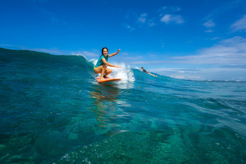 beautiful girl surfing on big transparent waves