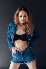 Portrait of a beautiful fashionable woman in black lingerie and denim shorts