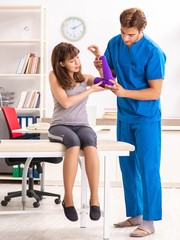 Fototapeta premium Young female patient visiting male doctor traumatologist