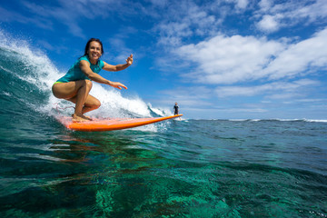 beautiful girl surfing on big transparent waves