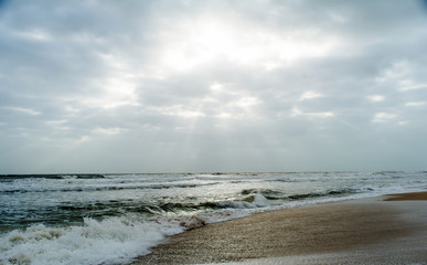 Sunshine pouring over the sea  through the clouds view from beach of somnath temple Gujarat India
