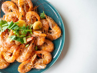 Baked Shrimp Whole shell with salt, frogs, garlic for fragrance Garnish with spring onions and coriander on a round dish,White background