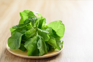 Green Thai spinach leaf or edible amaranth (Asian plant) on wooden plate, Organic vegetables