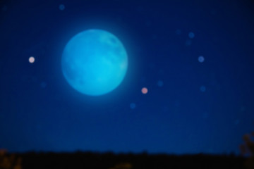 Fototapeta na wymiar Full blue Moon on a starry skies. De-focused photo.