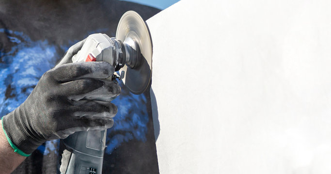worker cutting stone with grinder