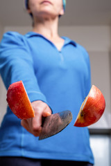 Extreme closeup of woman cutting apple in half mid air with shallow focus